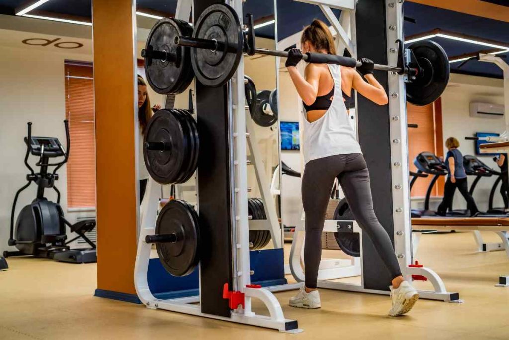 woman doing lunge on smith machine